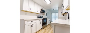 A kitchen with white cabinets and a black oven.